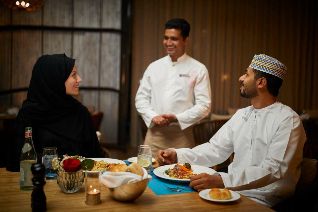 Millennium Resort Salalah Exterior foto A waiter serving food to guests